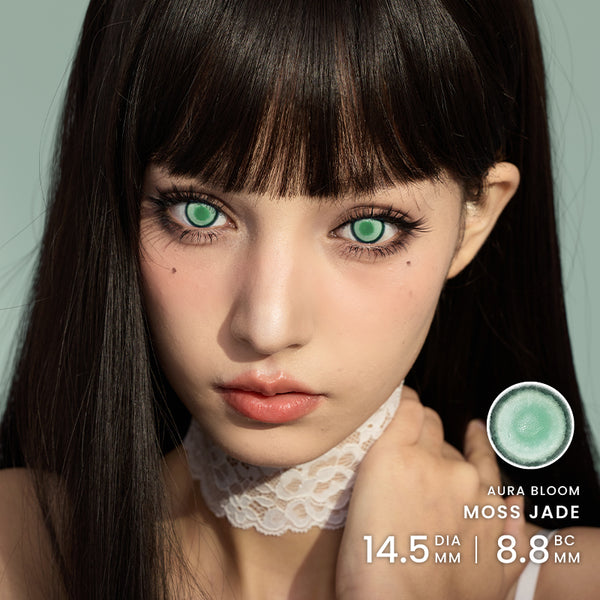 Close-up portrait of a model wearing large green contact lenses, 'AURA BLOOM MOSS JADE 14.5 DIA MM | 8.8 Base Curve