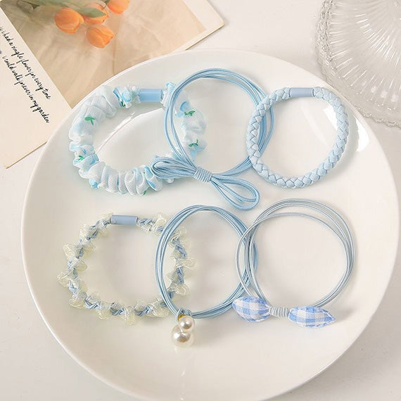 Display of six pastel floral hair ties in a set, featuring various soft color tones for versatile, cute hair accessories 